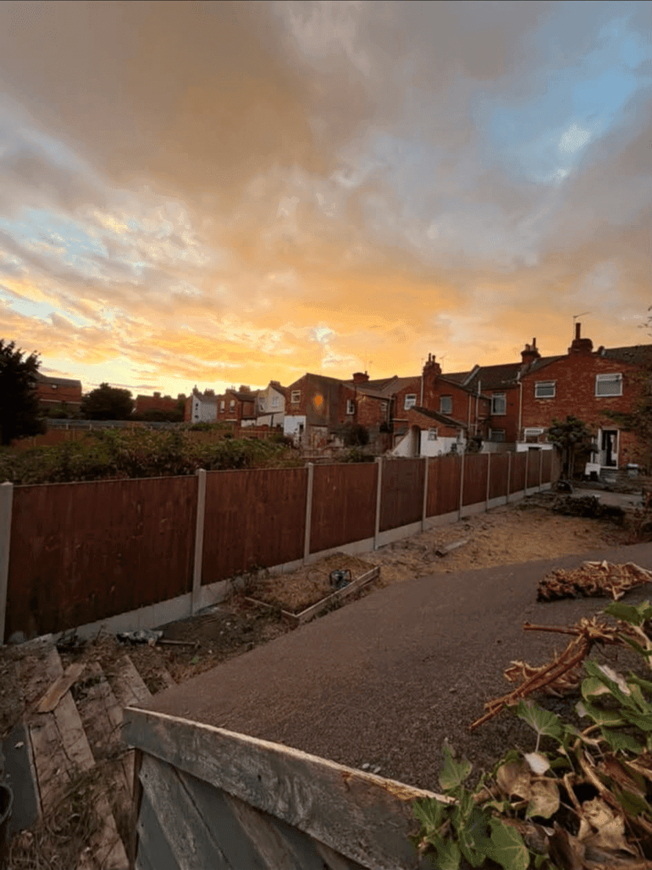Completed garden with new fencing and a fresh path photographed at sunset