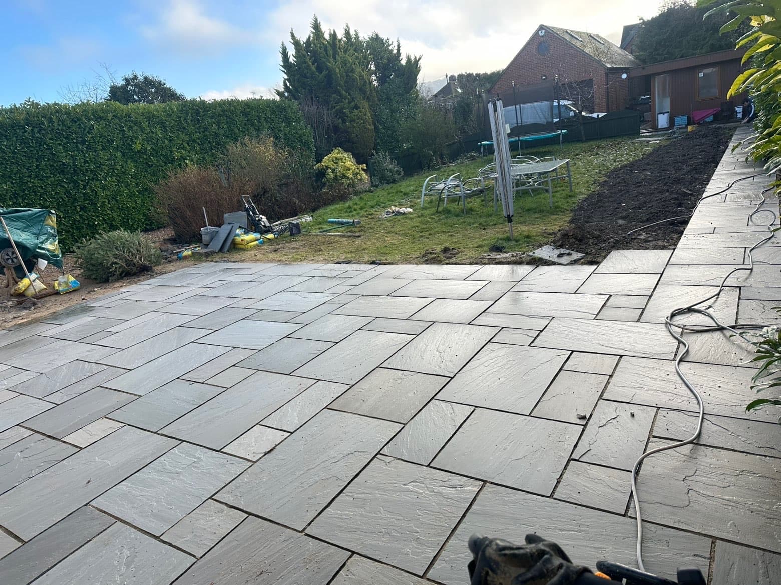 Indian sandstone patio in random pattern with large garden