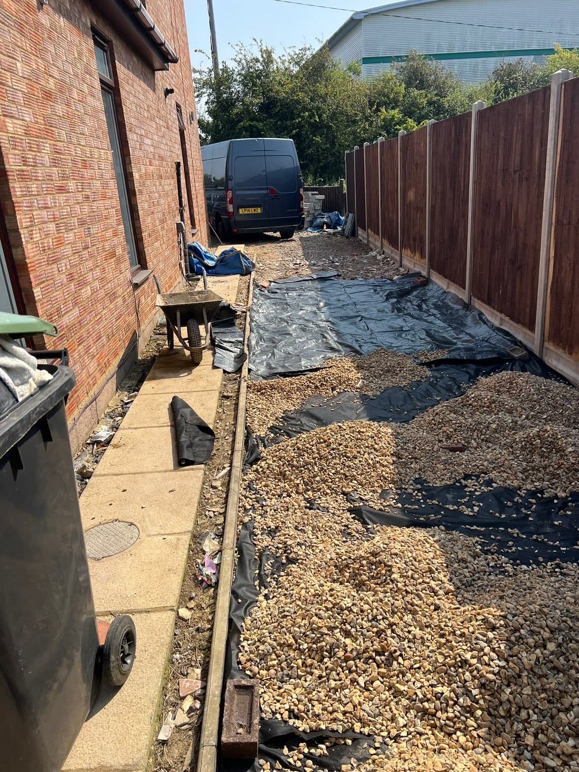 Progress photo showing membrane and gravel being installed along the side access