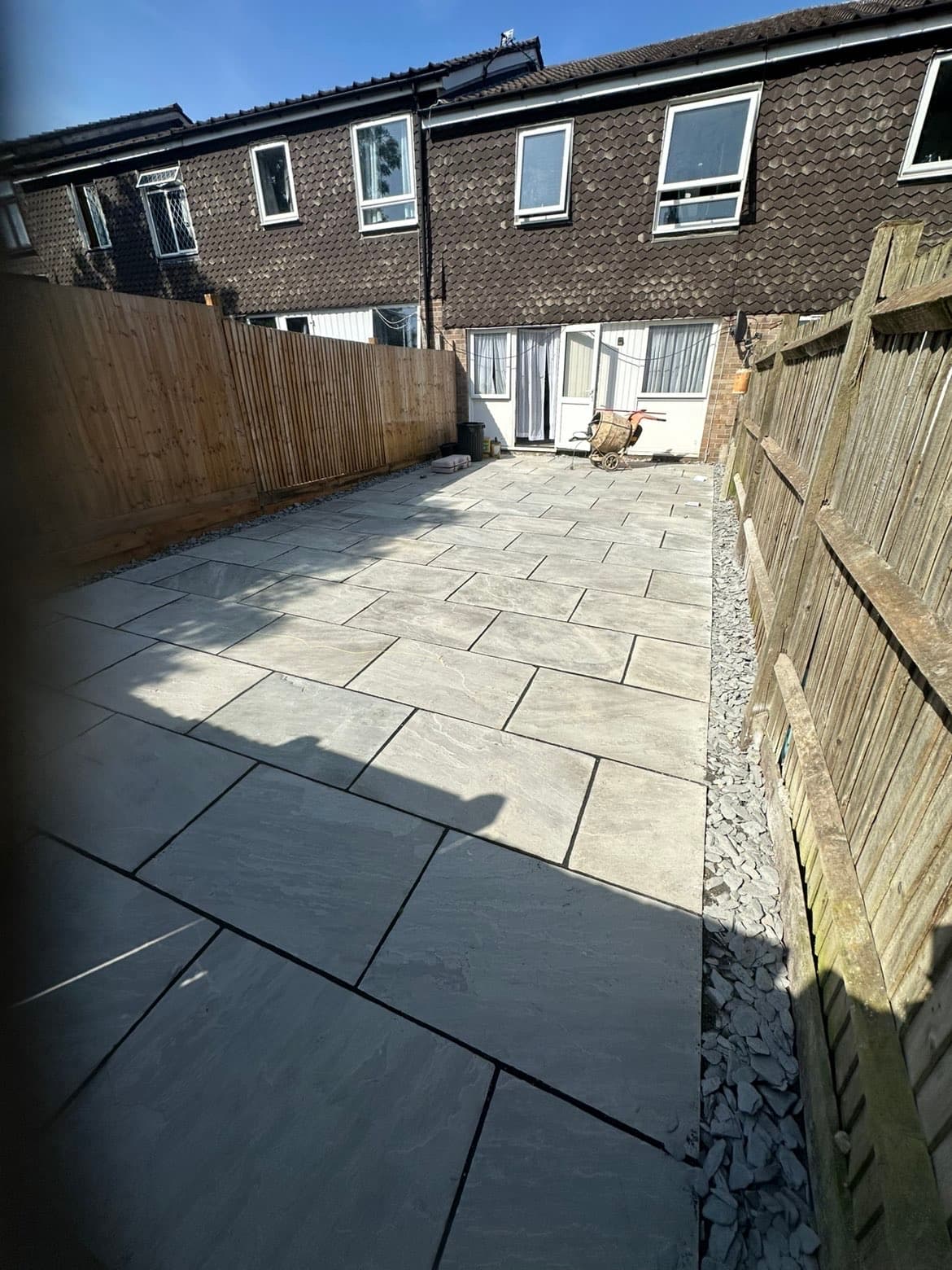 Kandla grey Indian sandstone patio with new timber fencing and slate gravel drainage borders