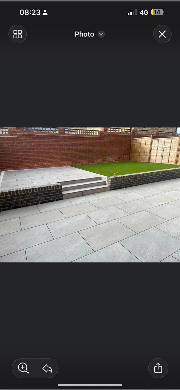 Artificial lawn with brick edging and porcelain patio